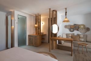 a bedroom with a bed and a table and a mirror at Kosmitis Suites & Villas in Naousa