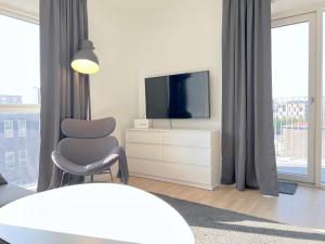 a living room with a tv and a chair at Modern Spacious 3 Bedroom Apartment At Ricahrd Mortensens Vej With Balcony Close To The Royal Arena And Fields in Copenhagen
