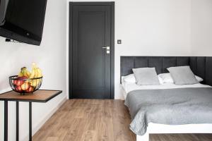 Un dormitorio con una cama y una mesa con un bol de fruta en Apartamenty przy plaży, en Jastarnia