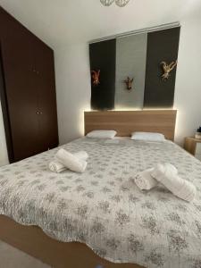 a bedroom with a bed with two towels on it at Comfy Myrvalis Apartment in Agia Triada