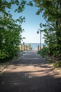 a road leading to the beach with the ocean at Apartamenty przy plaży in Jastarnia