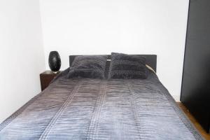 a bed with black comforter and pillows on it at Villa pont du Gard 4 Bedrooms in Remoulins