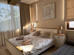 a bedroom with a bed with two slippers on it at Private seaview villa in BlackSeaRama - 1st line in Balchik +64 photos