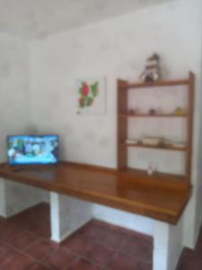 una mesa de madera en una habitación con un estante en La casita de Ahinoan. en Barbate