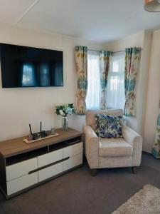 a living room with a tv and a chair at Caravan on Mersea Island Away Resorts Quiet Location in East Mersea