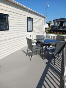 a patio with a table and chairs next to a building at Caravan on Mersea Island Away Resorts Quiet Location in East Mersea