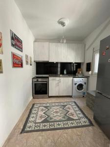 a kitchen with white cabinets and a rug on the floor at Comfy Myrvalis Apartment in Agia Triada