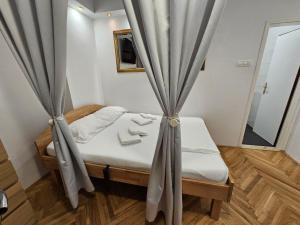 イゾラにあるD&D Izola apartments 2のカーテン付きのベッドが備わる小さな客室です。