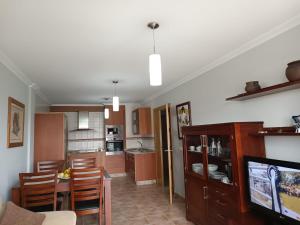 德島阿羅薩的住宿－Apartamento Isla de Arousa - Riasón，厨房以及带桌子和电视的用餐室。