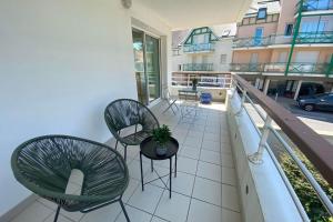 a balcony with chairs and a potted plant on it at Bright 56m near Pornichet's hypercentre in Pornichet