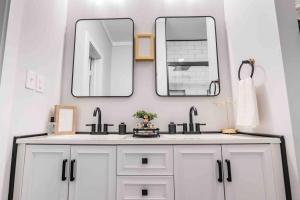 a bathroom with a white sink and two mirrors at Cozy Cottage at the Springs in De Leon Springs