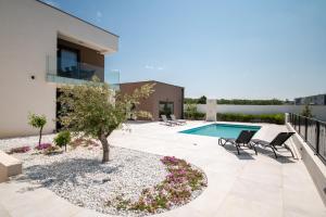 une terrasse avec une piscine, un arbre et des chaises dans l'établissement Vrsi Seaside Heights Apartments, à Vrsi