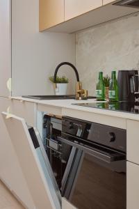 a kitchen with a dishwasher and a sink with green bottles at Błękitna Laguna in Zator