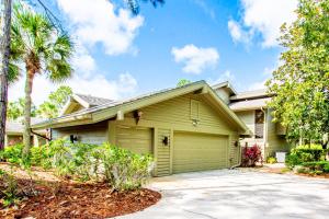 a house with a green garage and palm trees at Magnolias on Cobblestone in Wesley Chapel