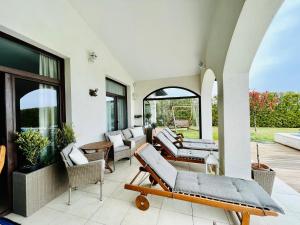 un patio con sofás y sillas en un porche en Private seaview villa in BlackSeaRama - 1st line, en Balchik