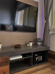 a entertainment center with a large television on a wall at Sea Flower apartment Rijeka in Rijeka