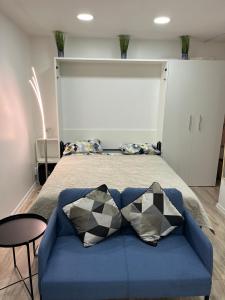 1 dormitorio con 1 cama y 1 sofá azul en Studija Vytauto 22 en Klaipėda
