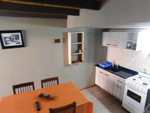 a kitchen with a table and a stove top oven at Un lugar en el mundo in Mina Clavero