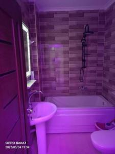 - une salle de bains rose avec baignoire et lavabo dans l'établissement شقة رائعة قريبة من الاهرامات بالجيزة داخل كومبوند خاص, à ‘Ezbet `Abd el-Ḥamîd