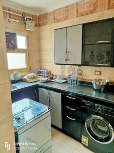 Il comprend une cuisine équipée d'une cuisinière et d'un lave-vaisselle. dans l'établissement شقة رائعة قريبة من الاهرامات بالجيزة داخل كومبوند خاص, à ‘Ezbet `Abd el-Ḥamîd