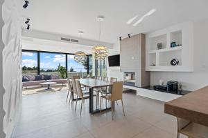 a kitchen and dining room with a table and chairs at Luxury, seafront Villa IVAN with heated pool only 100m from beach in Omiš