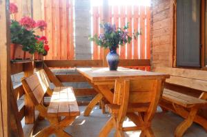 a table and two chairs with a vase of flowers on it at Casa Gherman in Turda