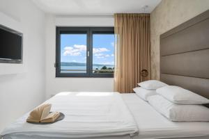 a bedroom with a large bed with a book on it at Luxury, seafront Villa IVAN with heated pool only 100m from beach in Omiš +42 photos