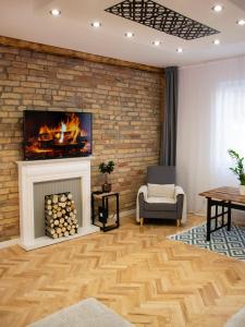 a living room with a fireplace and a brick wall at Season One Apartman in Szeged