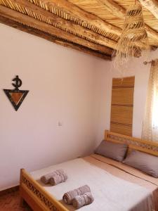 a bedroom with a bed with two towels on it at Ksar Montana Gîtes, Chambres piscine in Taforhalt