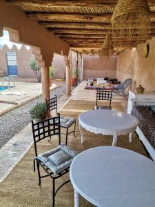 a patio with two tables and two chairs at Ksar Montana Gîtes, Chambres piscine in Taforhalt