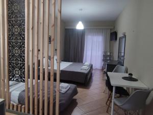 Pokój hotelowy z 2 łóżkami, stołem i biurkiem w obiekcie olivegrove w Sidari