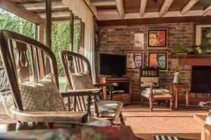sala de estar con mecedoras y TV en Acogedora Casa Campestre en Chia BBQ Parqueadero Privado incluido, en Chía