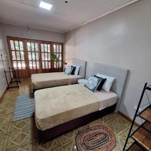 een slaapkamer met 2 bedden in een kamer bij Naturalis Flats and Suites in Puerto Iguazú