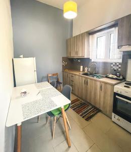 uma cozinha com uma mesa branca e um frigorífico branco em Maria house em Eleonas