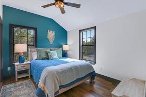 a blue bedroom with a bed and a ceiling fan at Terlingua at the Bend in Wimberley