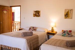 um quarto com duas camas e um candeeiro sobre uma mesa em Spacious artsy home with fast WiFi em Oaxaca de Juárez