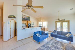 uma sala de estar com 2 cadeiras azuis e uma ventoinha de tecto em Casa Vista Bullhead City Home with Patio and View! em Bullhead City