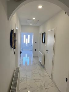 un corridoio con pavimento piastrellato e una porta bianca di Apartments NONO a Senj