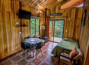 a bedroom with a bed and a table in a room at Cabañas Hoja Verde in Monteverde Costa Rica