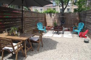 a patio with chairs and a table and an umbrella at Perfectly Located Modern 2BR w Priv Backyard in Brooklyn