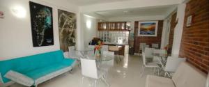 uma sala de estar com um sofá, uma mesa e cadeiras em Alojamiento Turístico Verano Azul San Andrés em San Andrés