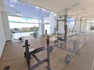 a gym with cardio equipment and a large window at Hogareña, familiar, mi casa in Santa Cruz de la Sierra