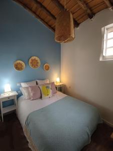 a bedroom with a bed with two tables and two lamps at Poial da Bia in Mértola