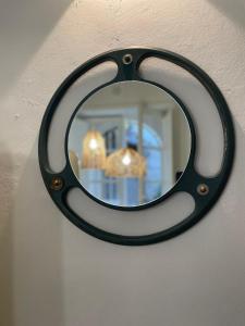 a mirror with a black frame hanging on a wall at Ortigia_corte d'avolio in Siracusa