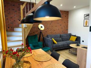 - un salon avec une table et un canapé bleu dans l'établissement Apartament Kamienica Loft, à Kudowa-Zdrój