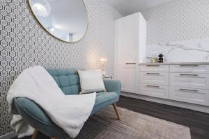 Cosy Bulle في رانس: غرفة معيشة مع أريكة زرقاء ومرآة