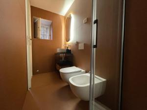 a small bathroom with a toilet and a sink at Ortigia_corte d'avolio in Siracusa