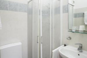 un bagno bianco con doccia e lavandino di Caravella a Deiva Marina