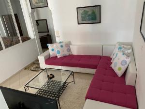 salon z fioletową kanapą i stołem w obiekcie Villa Curubis Korba w mieście Korba