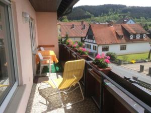 balcón con 2 sillas y vistas a la ciudad en Ferienwohnung Leonhard Müller en Marktrodach